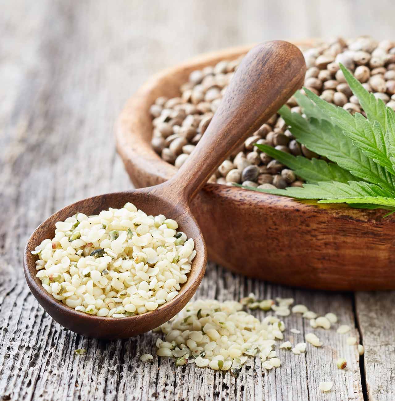 organic hulled hemp seeds with plant on wood